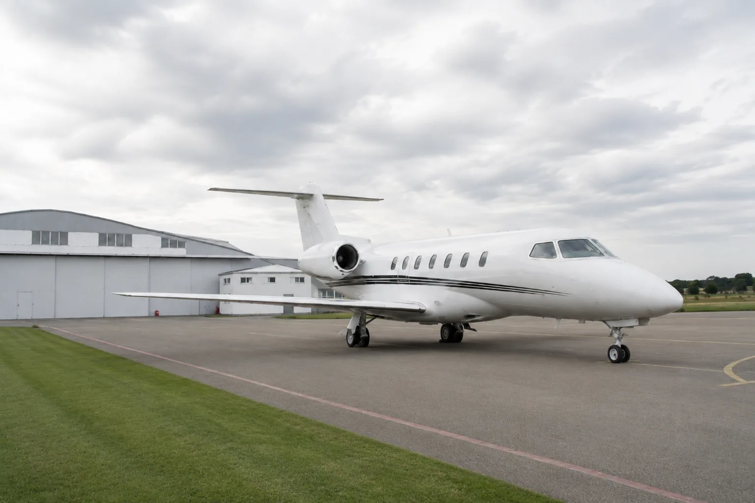 Jet d'affaires immobile sur une aire de stationnement française